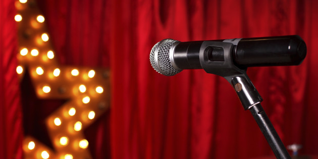 microphone on theater stage ,golden star on background  with red curtains